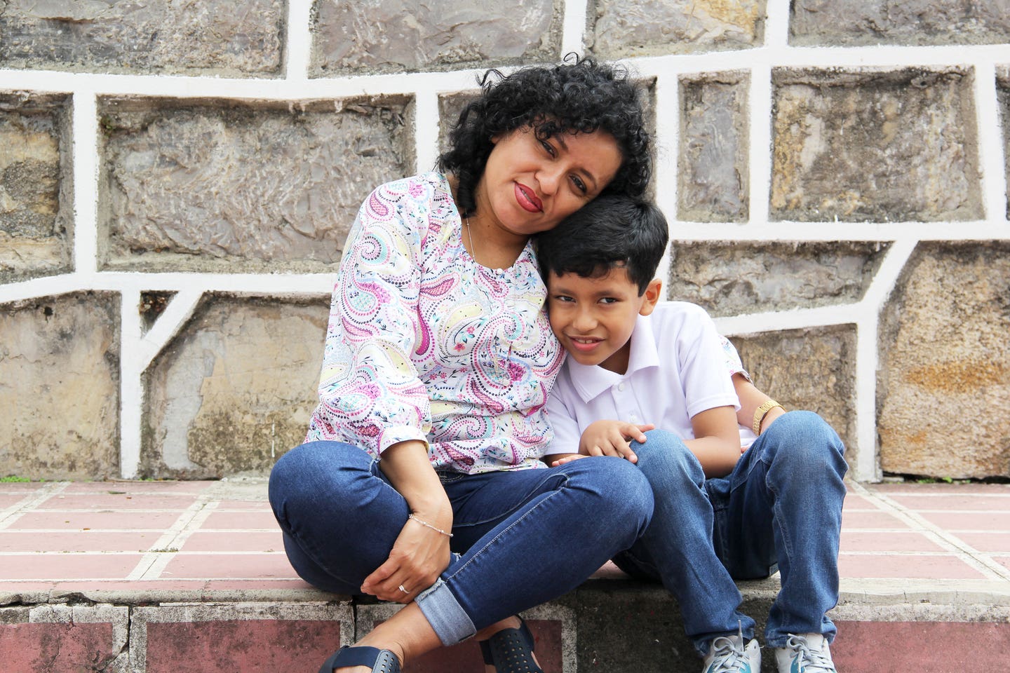 Dark-haired mom and son play and have fun together spend quality time playing in a park without toys or a cell phone they live in poverty and happiness