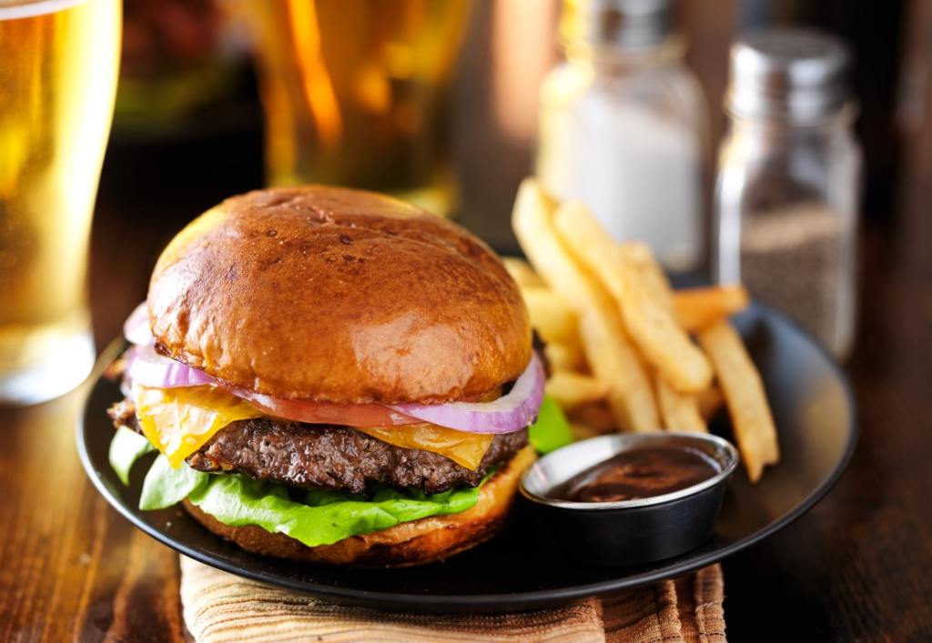 cheeseburger and fries on plate served with beer at restaurant. burger in fort myers